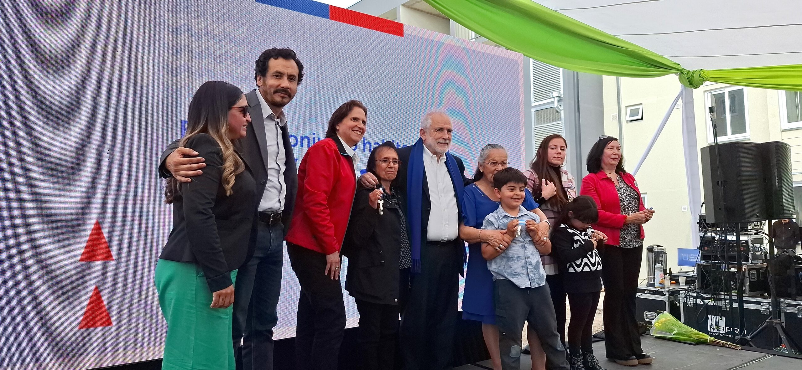 Familia sonriendo frente a su nueva vivienda
